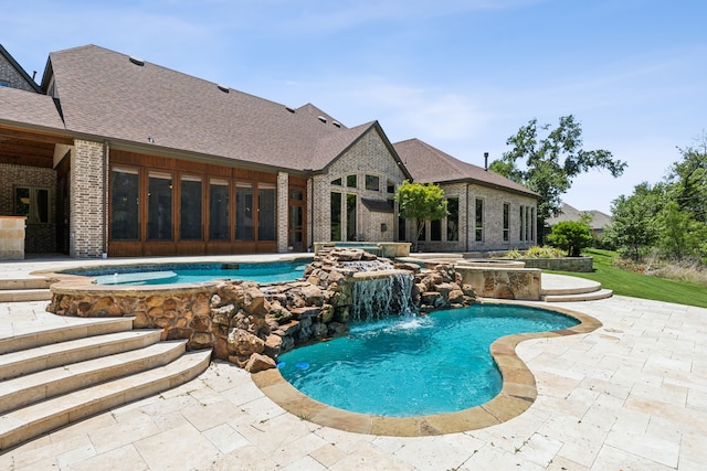 view of swimming pool with an in ground hot tub, pool water feature, and a patio area