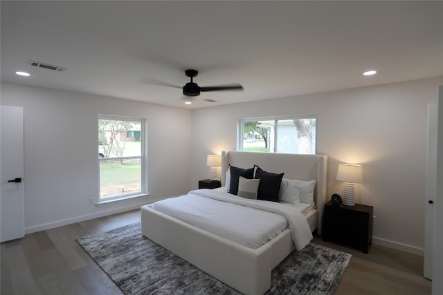 bedroom with hardwood / wood-style flooring, ceiling fan, and multiple windows