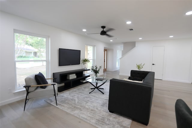 living room with a wealth of natural light, ceiling fan, and light hardwood / wood-style floors