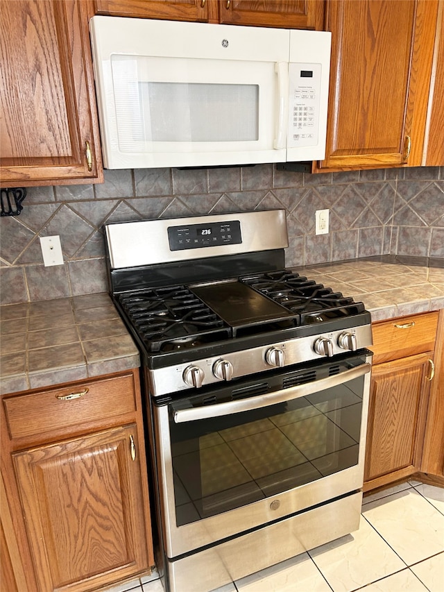 kitchen with backsplash and stainless steel gas range oven