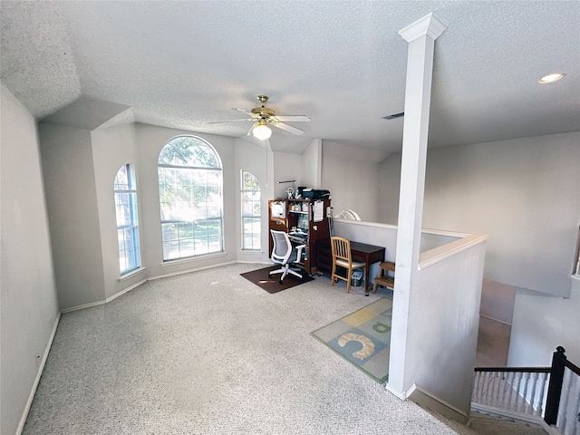 carpeted home office with lofted ceiling, ceiling fan, and a textured ceiling