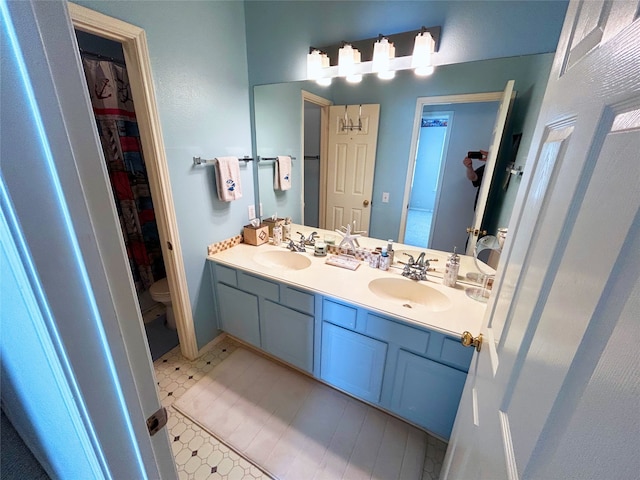 bathroom featuring tile patterned flooring, vanity, and toilet