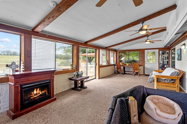 sunroom with ceiling fan and vaulted ceiling with beams