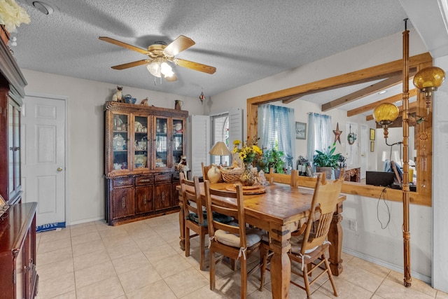 tiled dining area with ceiling fan, a textured ceiling, and beamed ceiling