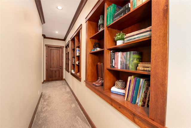 hall featuring crown molding, built in features, and carpet