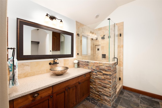 bathroom featuring tile flooring, lofted ceiling, backsplash, a shower with door, and vanity