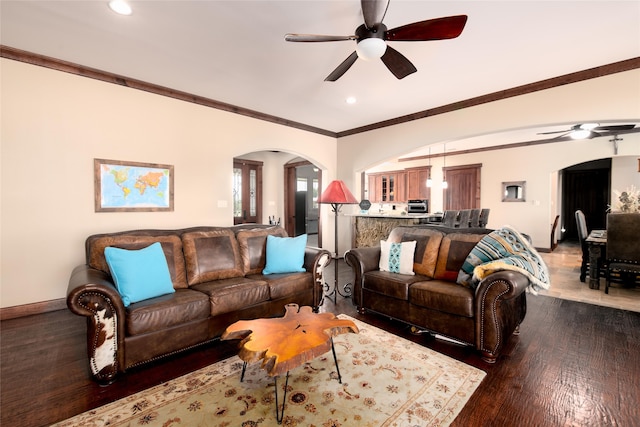 living room featuring dark hardwood / wood-style flooring, ornamental molding, and ceiling fan