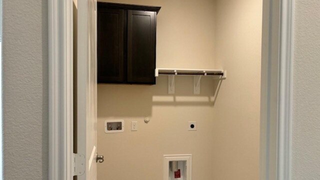 washroom with cabinets, gas dryer hookup, electric dryer hookup, and washer hookup