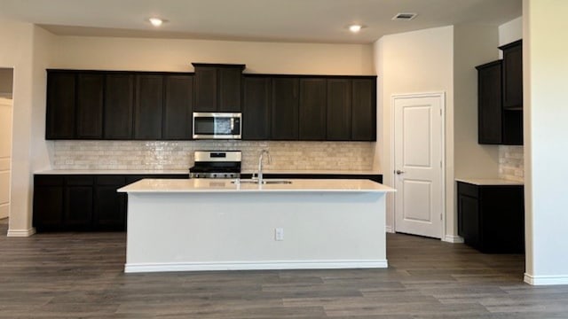 kitchen featuring a kitchen island with sink, stainless steel appliances, sink, and dark hardwood / wood-style floors