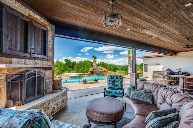 view of patio with an outdoor living space with a fireplace and ceiling fan