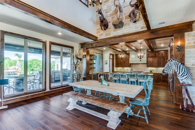 dining area featuring dark hardwood / wood-style flooring, beamed ceiling, and a notable chandelier