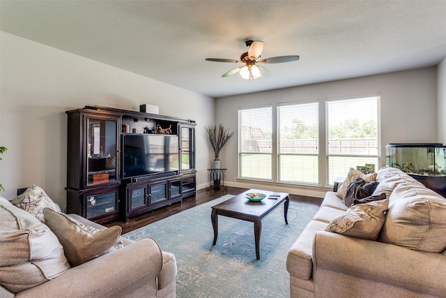 living room with a textured ceiling, dark hardwood / wood-style flooring, and ceiling fan