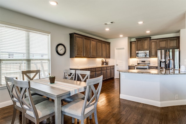 dining area with dark hardwood / wood-style floors and sink