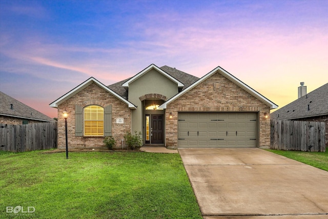 view of front of property featuring a garage and a lawn