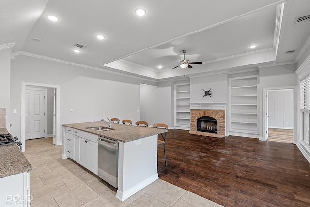 kitchen with white cabinetry, sink, a tray ceiling, and stainless steel dishwasher