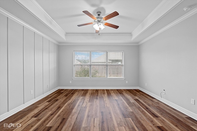 spare room with crown molding, a tray ceiling, wood-type flooring, and ceiling fan