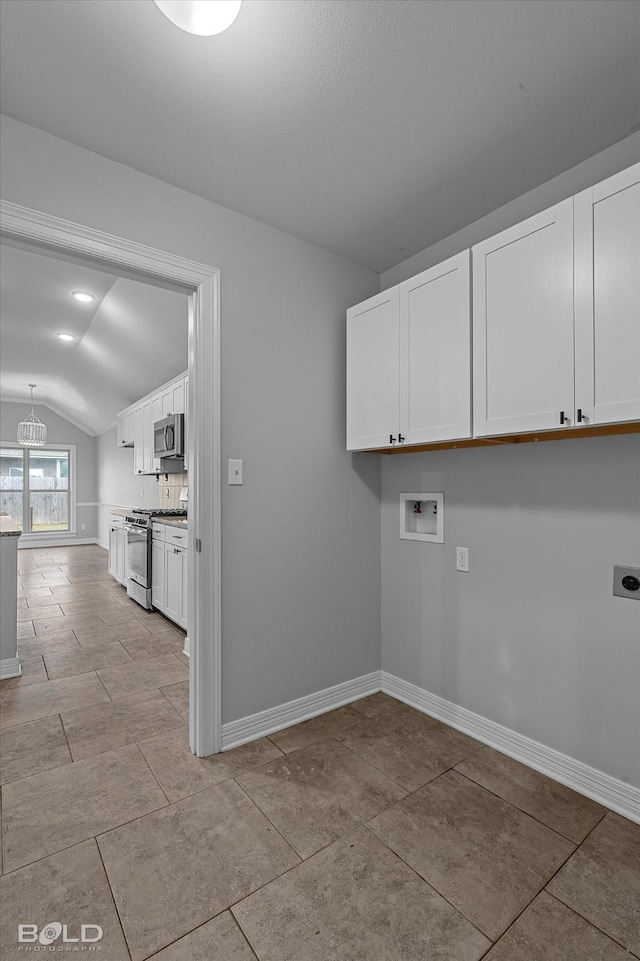 laundry room featuring electric dryer hookup, cabinets, light tile patterned floors, hookup for a washing machine, and a notable chandelier