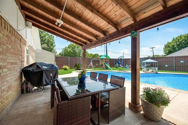 view of pool featuring a playground and area for grilling