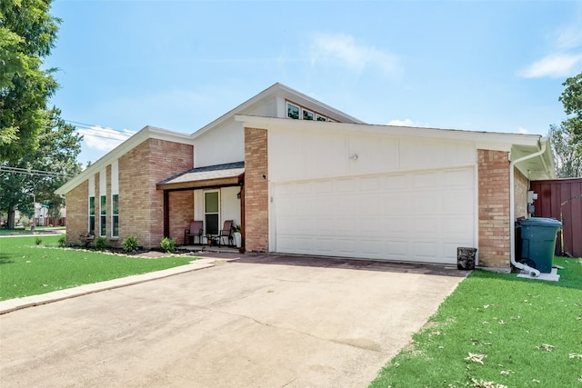 single story home with a porch, a garage, and a front lawn