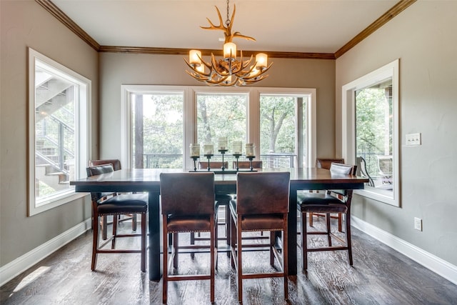 dining room with an inviting chandelier, ornamental molding, and dark wood-type flooring