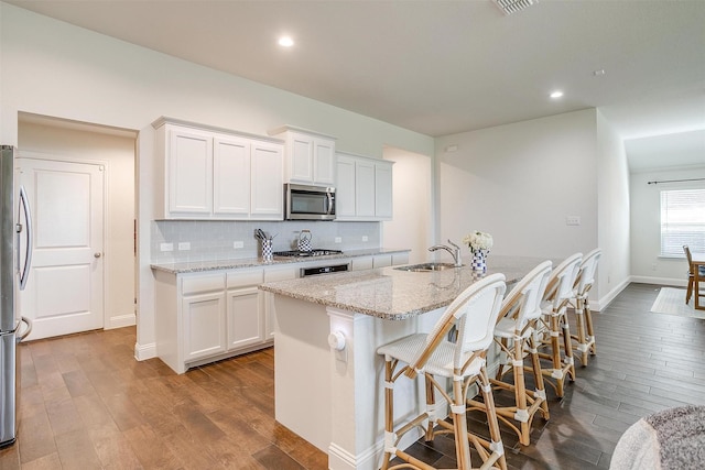 kitchen featuring appliances with stainless steel finishes, sink, a center island with sink, and white cabinets