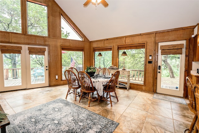 tiled dining space with high vaulted ceiling and ceiling fan