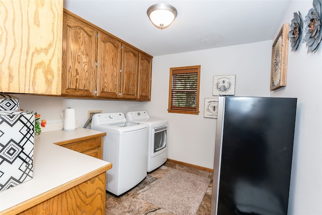 laundry area featuring separate washer and dryer, cabinets, and light tile floors