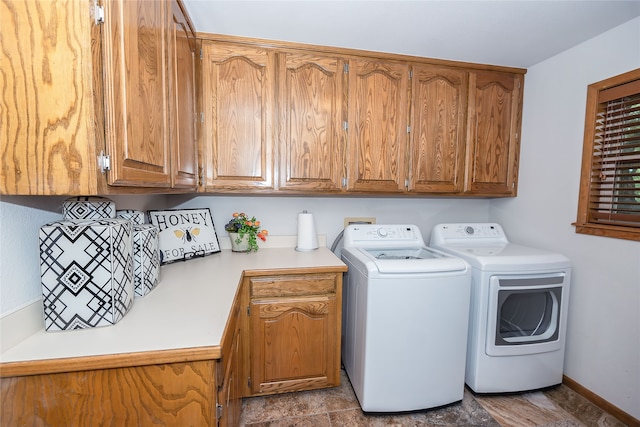 clothes washing area featuring washer and clothes dryer and cabinets