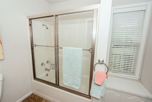 bathroom featuring toilet and enclosed tub / shower combo