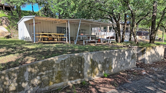 back of property featuring an outdoor structure