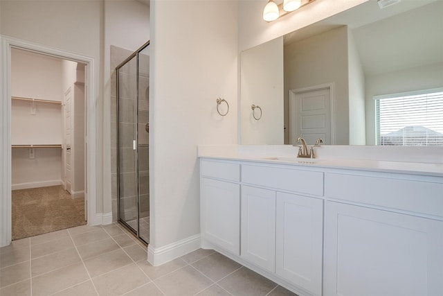 bathroom with tile patterned flooring, vanity, and a shower with door