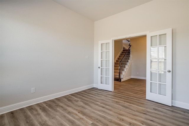 empty room with hardwood / wood-style flooring and french doors