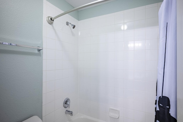 bathroom with shower / tub combo and toilet