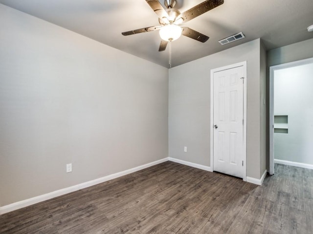 empty room with ceiling fan and dark hardwood / wood-style floors