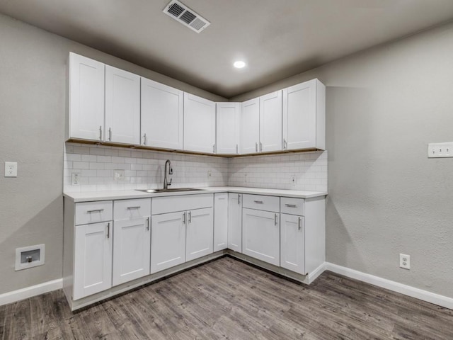 kitchen with white cabinets, sink, and hardwood / wood-style floors