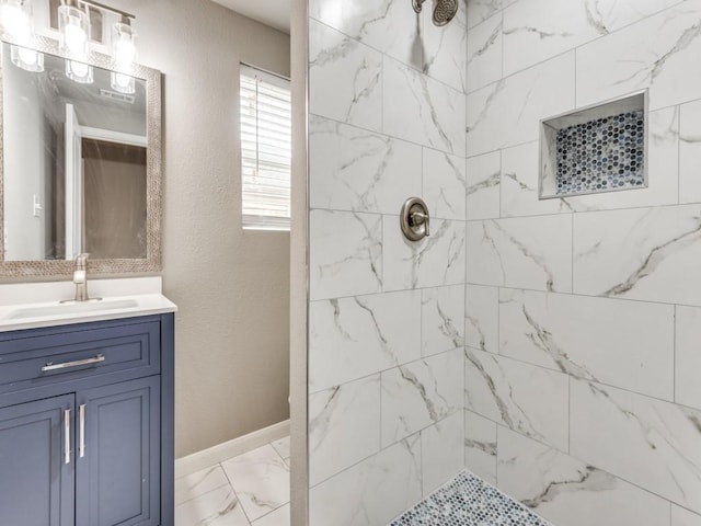 bathroom with tiled shower and vanity