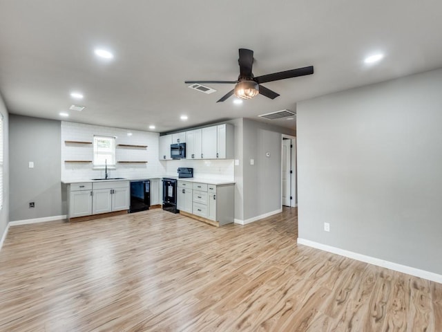 kitchen featuring black appliances, sink, light hardwood / wood-style flooring, tasteful backsplash, and white cabinetry