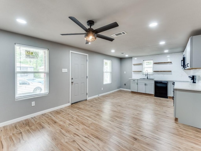 kitchen featuring ceiling fan, sink, black dishwasher, light hardwood / wood-style flooring, and white cabinets