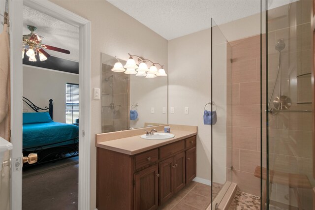 bathroom featuring tile patterned floors, vanity, a textured ceiling, and a tile shower