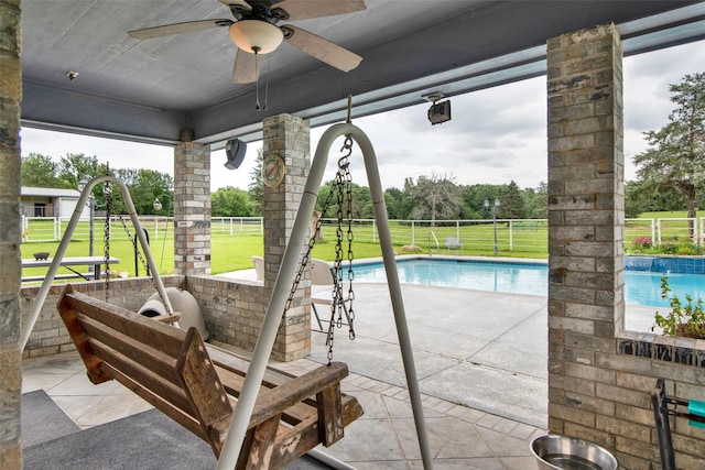 view of patio featuring a fenced in pool and ceiling fan