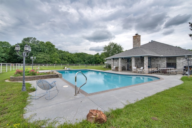 view of pool featuring a patio, a diving board, and a lawn