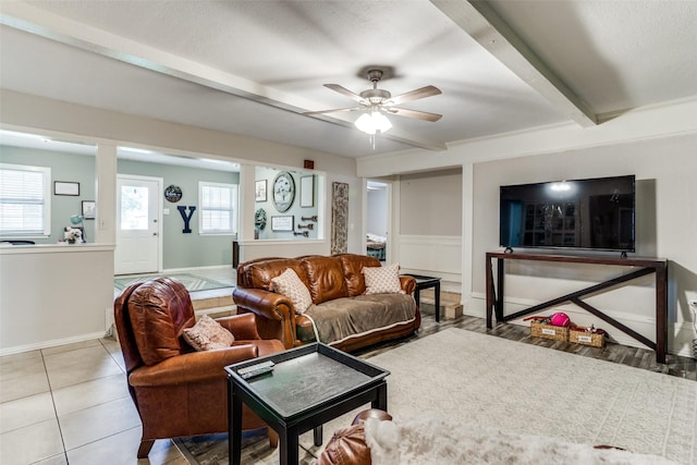 tiled living room with beam ceiling and ceiling fan