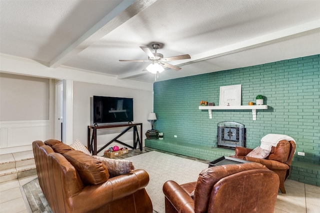 living room featuring brick wall, a textured ceiling, ceiling fan, beam ceiling, and light tile patterned floors