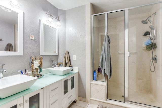 bathroom with tile patterned flooring, vanity, and walk in shower