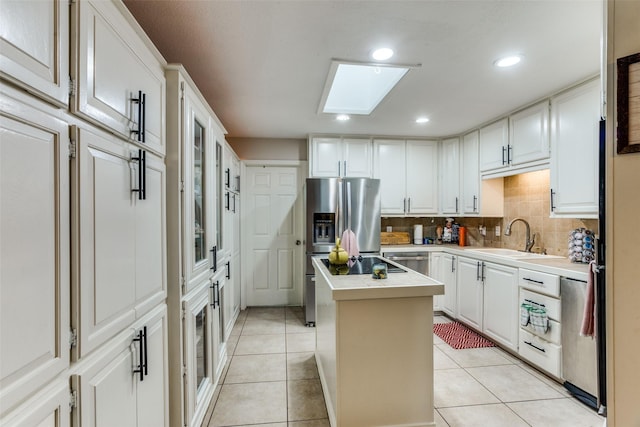 kitchen featuring tasteful backsplash, white cabinetry, sink, and a kitchen island