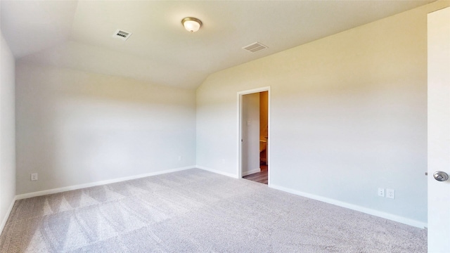 carpeted empty room with lofted ceiling