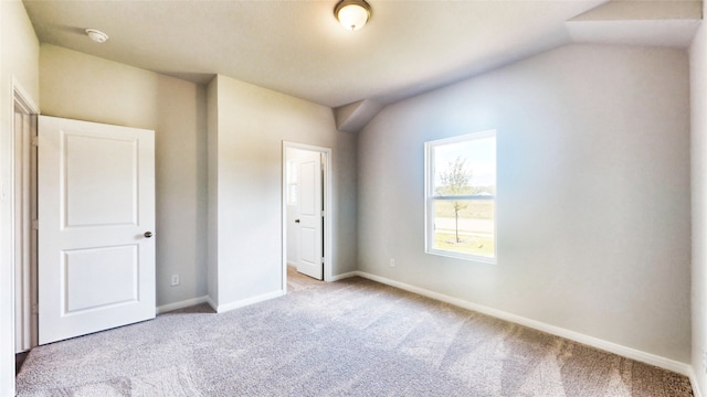 unfurnished bedroom featuring vaulted ceiling and light carpet