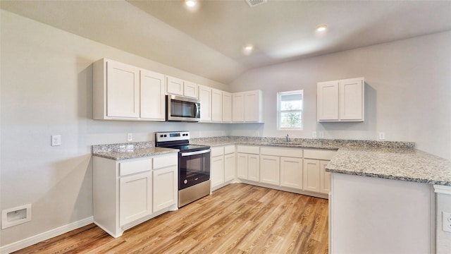 kitchen featuring light stone countertops, white cabinets, vaulted ceiling, light hardwood / wood-style flooring, and appliances with stainless steel finishes