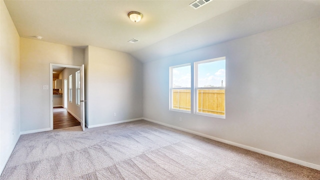 empty room featuring lofted ceiling and light colored carpet