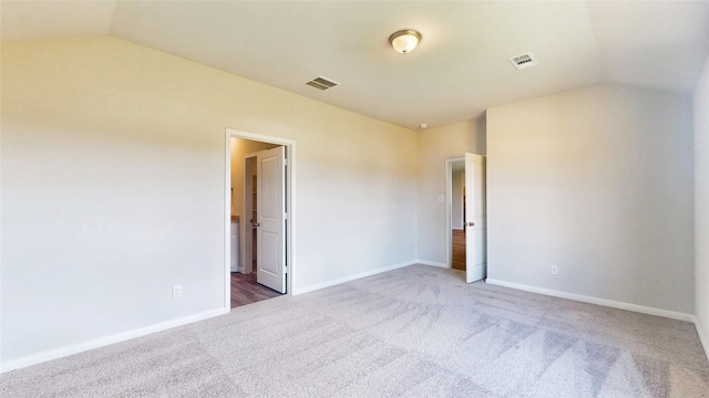 unfurnished room featuring lofted ceiling and carpet